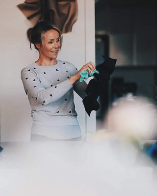 ARtist Rebecca Stevens stands in her home studio in a grey jumper, she's polishing one of her smaller sculptural works. 
