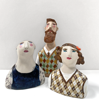 Three mini human figurines sculptures.