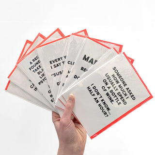 hand holding greeting cards. Each Card has a funny saying on the front.